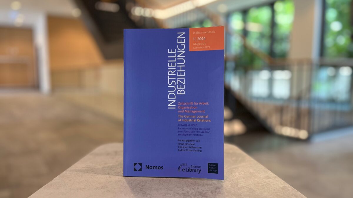 Im Mittelpunkt und Vordergrund des Bildes steht der Sonderband der Industriellen Beziehungen. Im Hintergrund ist verschwommen das Foyer der University of Labour erkennbar.