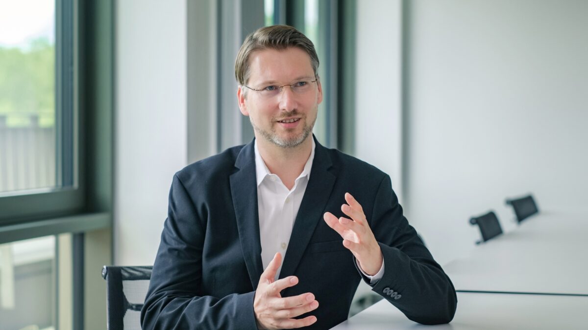 Philipp Donath befindet sich in einem Gespräch im Besprechungsraum der University of Labour. Er gestikuliert dabei mit den Händen.